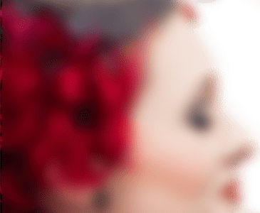 A blurred close up of a woman with red in her hair