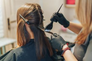 A hairstylist is dying a customer's hair